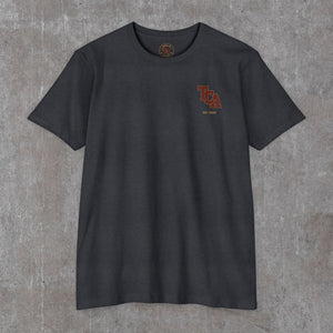 Front of the charcoal Honor the Tradition tee with the TCA monogram on the left chest
