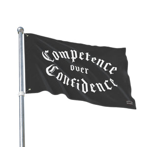 Competence over Confidence flag flying from a metal pole, white blackletter on black