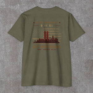 Military green 9/11 25th anniversary tee, back print: faded flag with rust-red Twin Towers and skyline
