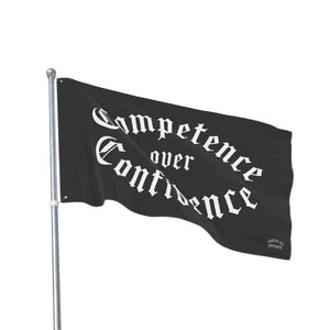 Competence over Confidence flag rippling on a flagpole against a white background