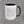 The 15 oz Hook Flag accent mug in white with a black handle, showing the full roof-hook flag artwork
