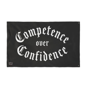 Full view of the Competence over Confidence flag, arched blackletter lettering with the Truck Co. Apparel mark