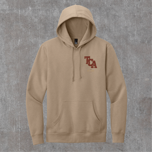 Front of the desert tan Honor the Tradition hoodie with the TCA monogram on the left chest