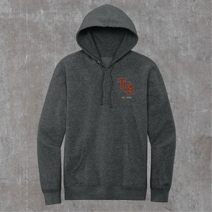 Front of the heathered charcoal Honor the Tradition hoodie with the TCA monogram on the left chest